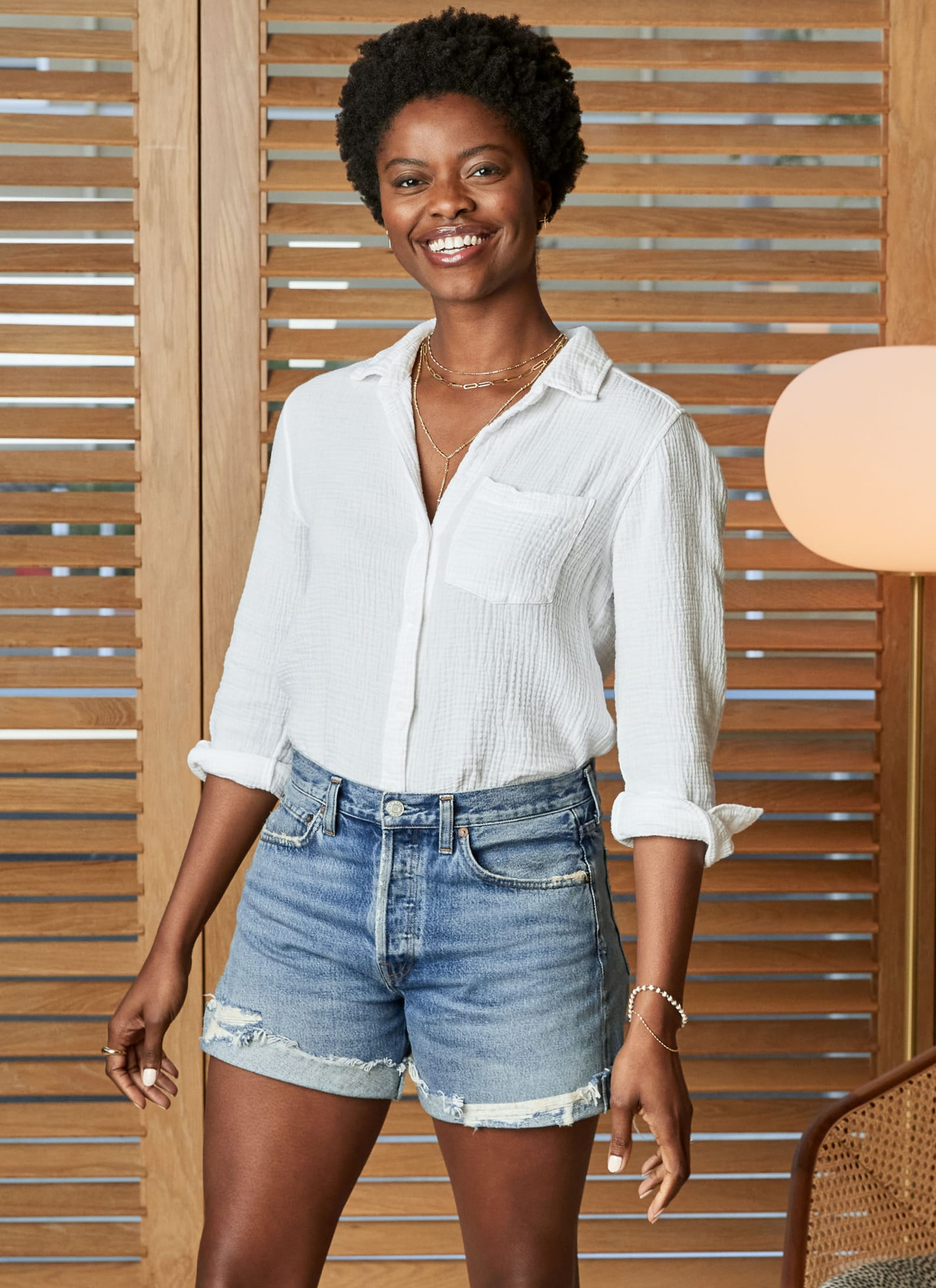 Woman wearing white button down with jean shorts