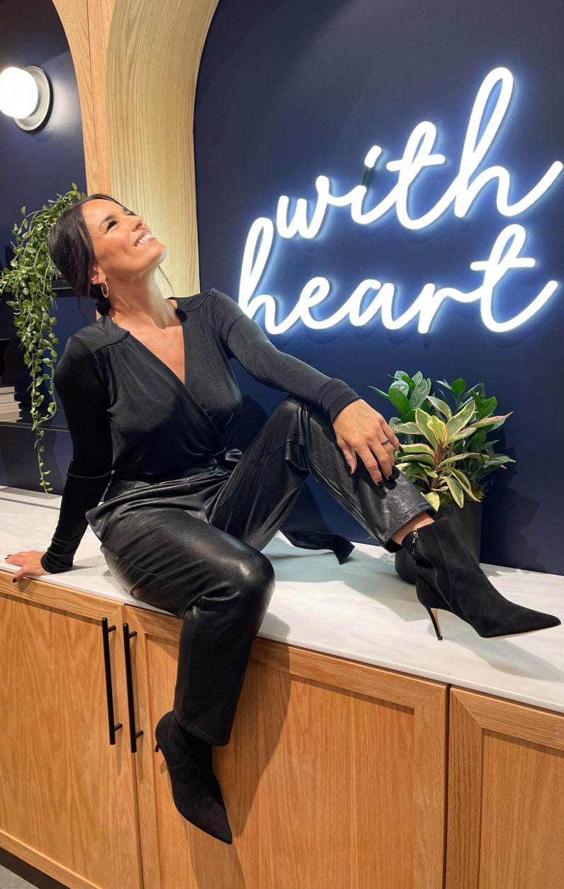 Woman wearing black blouse and vegan leather pants