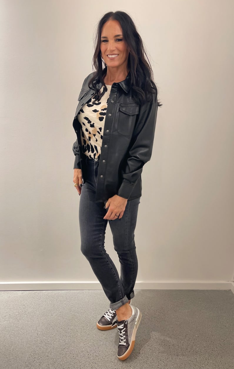 Woman wearing  shacket, animal print tee, and black jeans