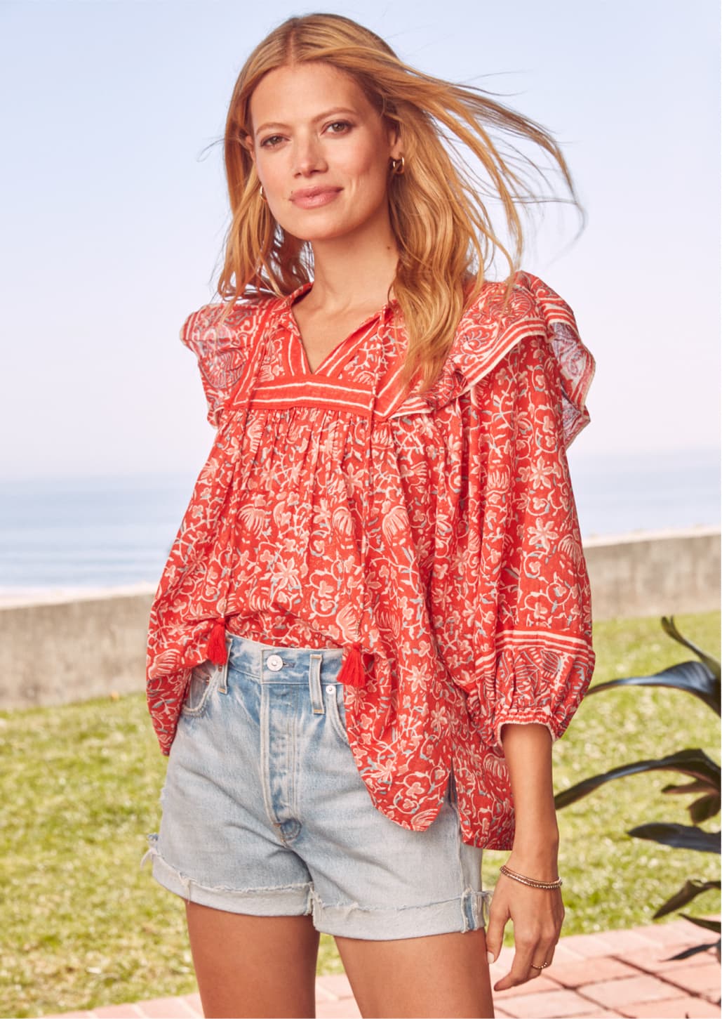 woman wearing a floral, ruffled statement top